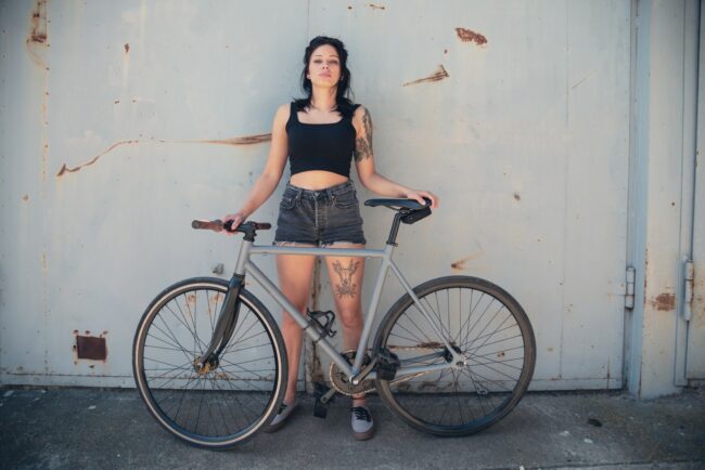 Portrait of a tattooed young woman with bicycle